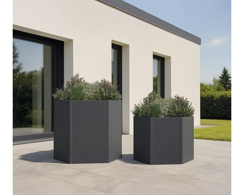 Twee zeshoekige plantenbakken met beplanting in de tuin.