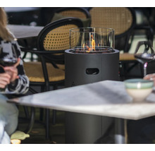 Tafelhaard met glazen cilinder en open vlam op een restauranttafel