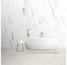 Lichte badkamer met vrijstaand bad, kraan, vloerkleed en bijzettafel