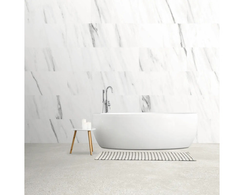 Lichte badkamer met vrijstaand bad, kraan, vloerkleed en bijzettafel