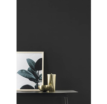 Decoratieve scène met afbeelding, houder en schaal op een tafel.