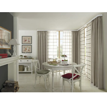 Eetkamer met ronde tafel, stoelen en gordijnen aan een gordijnroede