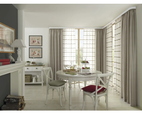 Eetkamer met ronde tafel, stoelen en gordijnen aan een gordijnroede