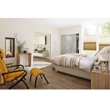 Lichte slaapkamer met open haard, fauteuil en badkamer toegang via een glazen deur