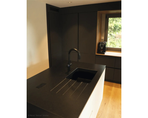 Keukenscène met spoelbak, kraan en keukenapparatuur voor het raam