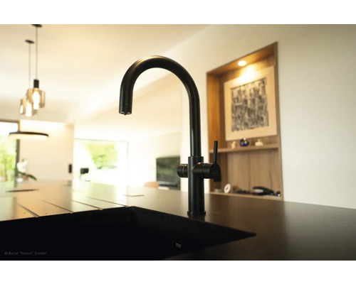 Zwarte keukenkraan op een gootsteen in een moderne keuken.