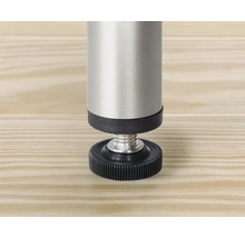 Detailopname van een verstelbare meubelpoot van metaal en kunststof op een houten oppervlak.