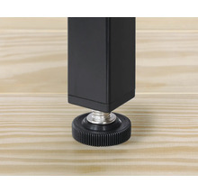 Detailopname van een zwarte tafelpoten met verstelbare voet op een houten vloer.