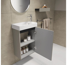 Badkamer met wastafel, kraan, spiegel, plank en handdoekhouder