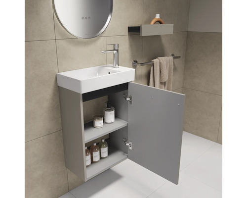 Badkamer met wastafel, kraan, spiegel, plank en handdoekhouder