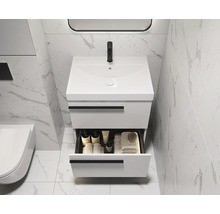 Moderne badkamer met witte wastafelonderkast en open lade voor badkamerbenodigdheden