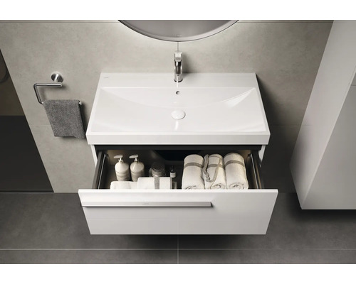 Badkamer wastafelonderkast met open lade, inclusief handdoeken en badartikelen.