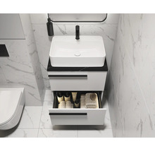 Moderne badkamer met witte wastafel en onderkast met open lade voor badkamerartikelen