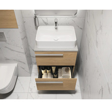 Badkamerwastafel met open lade, kraan en spiegel in lichte badkamer