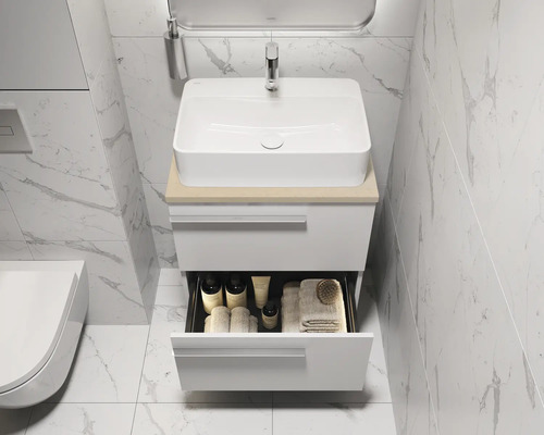 Badkamerwastafel met open lade gevuld met badkamerbenodigdheden zoals handdoeken en verzorgingsproducten