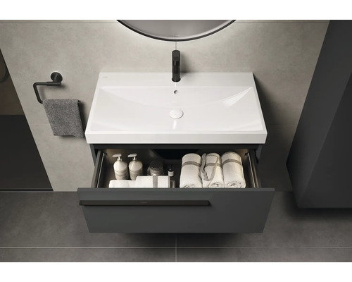 Wastafelmeubel met open lade, handdoeken en cosmetica in een moderne badkamer