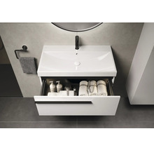 Moderne badkamer met witte wastafelonderkast, open lade en handdoeken