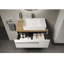 Moderne badkamer met wastafel, waskom en open lade met handdoeken en verzorgingsproducten.