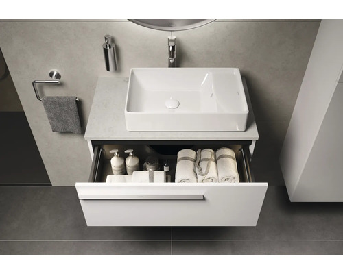 Badkamer met wastafel, open onderkast met handdoeken en verzorgingsproducten