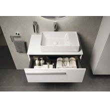 Moderne badkamer met wastafel, wasbak en open lade met handdoeken en badkamerbenodigdheden.