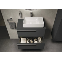 Moderne badkamer met grijze wastafelonderkast, witte opzetwastafel en open lade met badkamerbenodigdheden