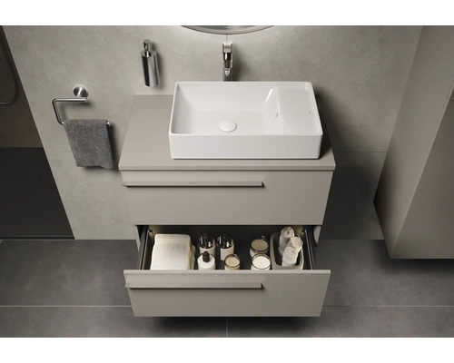 Badkamer met wastafel, onderkast en open lade voor het opbergen van badkamerartikelen