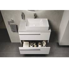 Moderne badkamer met wit badkamermeubel, waskom en open lade met badkameraccessoires.