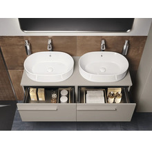 Badkamer met twee waskommen op een wastafelonderkast met open lades.