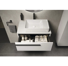 Moderne badkamer met wastafel, rechthoekige opzetwastafel en open lade met handdoeken en verzorgingsproducten.