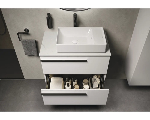 Moderne badkamer met wit wastafelonderkast, wastafel en open lade voor het opbergen van badkamerartikelen