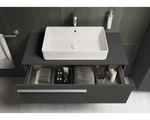 Moderne badkamer met wastafel, onderkast en open schuiflade voor het opbergen van handdoeken en verzorgingsproducten