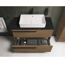 Moderne badkamer met wastafelonderkast, opzetwastafel en open lade.