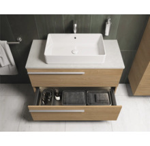 Moderne badkamer met wastafelonderkast, opzetwastafel en open lade.