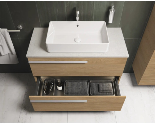 Moderne badkamer met wastafelonderkast, opzetwastafel en open lade.