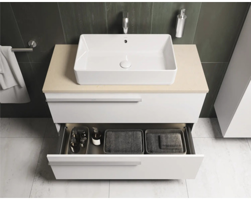 Badkamer met wastafel, onderkast en open lade voor het opbergen van badkamerbenodigdheden.