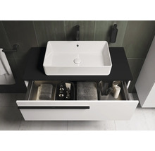 Wastafel met witte opzetwastafel en open lade voor badkamerbenodigdheden