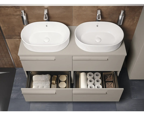 Dubbele wastafel met onderkast en open laden met toiletpapier en handdoeken