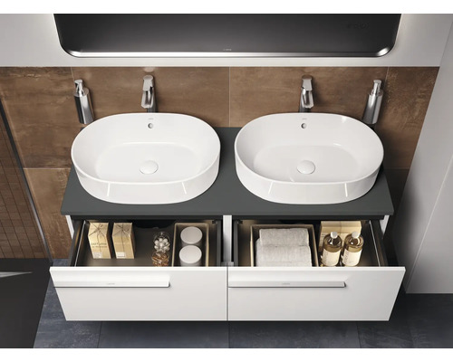 Badkamer met dubbele wastafel, onderkast en open laden voor het opbergen van badkamerartikelen.