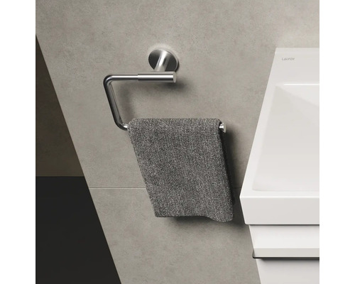 Metalen handdoekhouder met hangende handdoek in badkamer