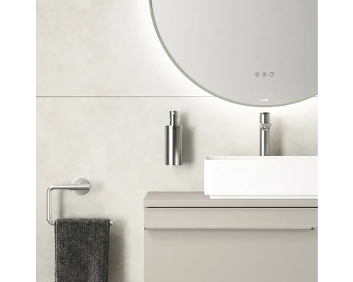 Modern badkamerinterieur met ronde spiegel, wastafel, kraan, zeepdispenser en handdoekhouder