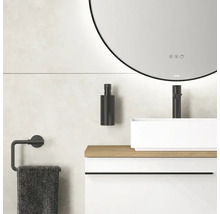 Badkamer met ronde spiegel, wastafel, kraan, zeepdispenser en handdoekhouder