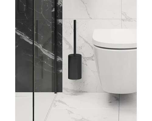 Zwarte wandtoiletborstel naast een toilet aan een betegelde muur.