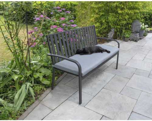 Tuinbank met grijze bekleding en liggende kat in de tuin.