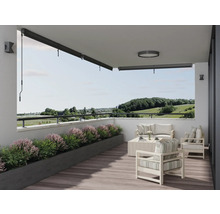 Licht terras met zonnescherm, tuinmeubelen en plantenbak