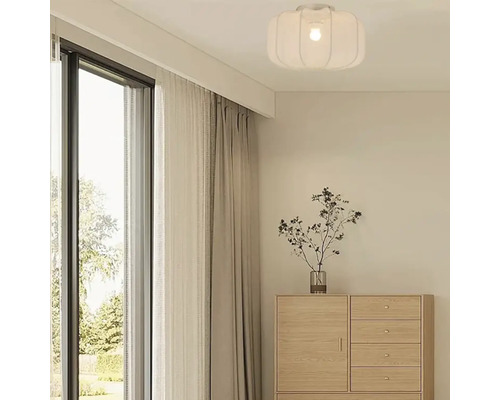 Woonkamer met plafondlamp, raam en commode