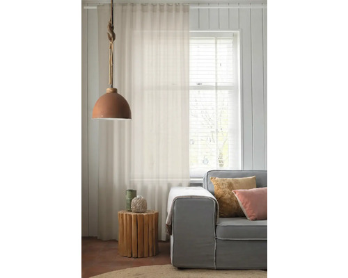 Woonkamer met gordijn, lamp en bank voor een lichte en vriendelijke sfeer.