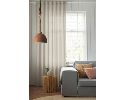 Woonkamer met grijze bank, houten bijzettafel, gordijnen en hanglamp