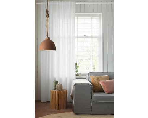 Woonkamer met bank, gordijn, hanglamp en houten bijzettafel