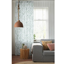 Woonkamer met gordijn met bladmotief, lamp en bank