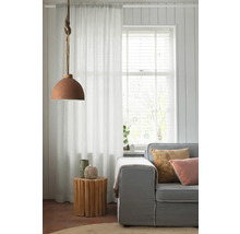 Woonkamer met bank, houten bijzettafel, gordijn en hanglamp